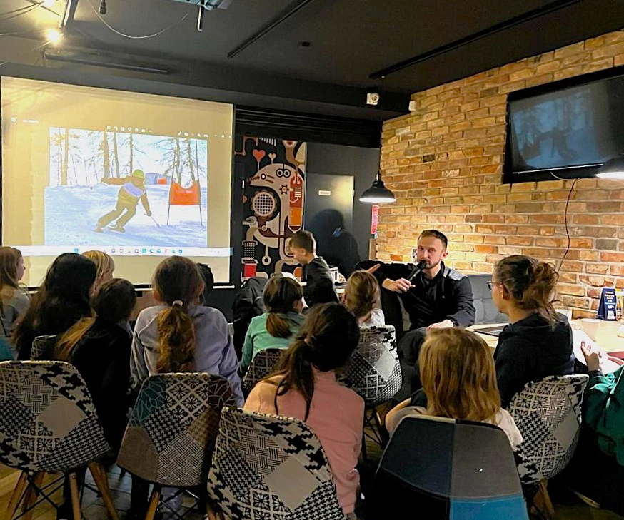 Uczniowie oglądają prelekcję ze stoku narciarskiego.