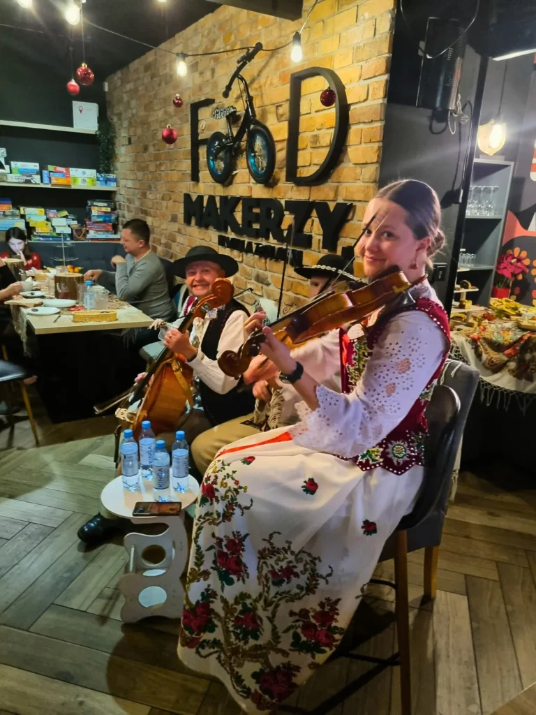 Kapela góralska umila czas gościom grając kolędy podczas bożego narodzenia w górach z kolacją wigilijną.